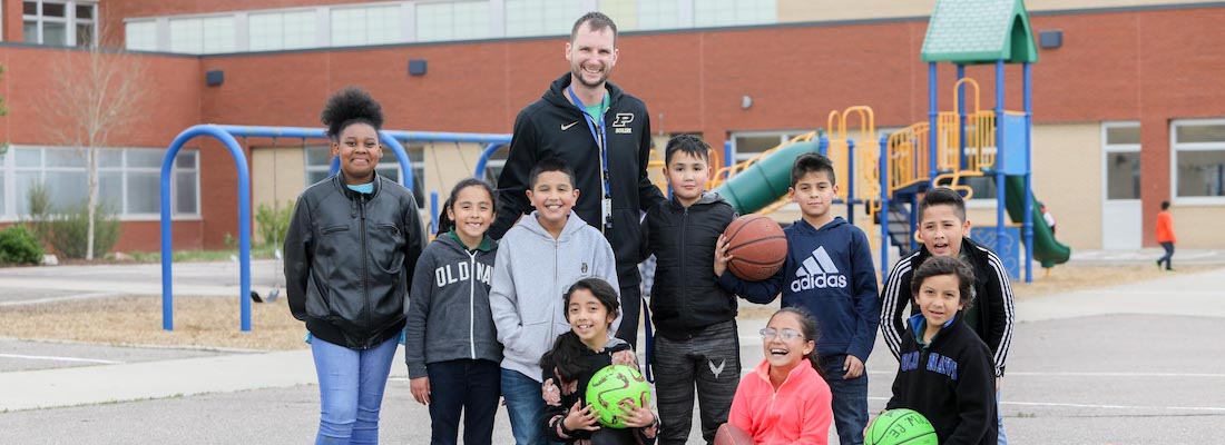 Group of students posing outside playing basketball