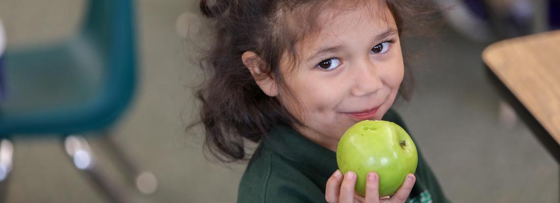 Student posing eating an apple